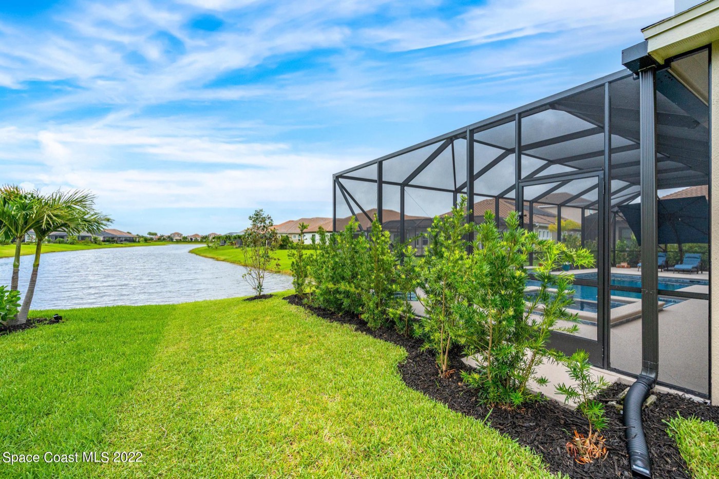 Lawn running to the lake beside the pool enclosure
